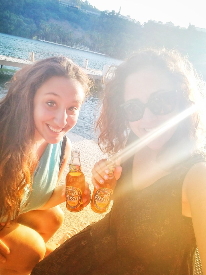 Two women drinking beer on the beach in St Lucia