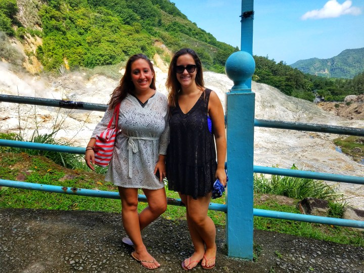 Two women pose against a backdrop of a mountain in St Lucia