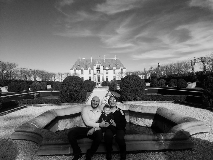 A family psoes for a photo with the backdrop of Oheka Castle, the inspiration for the mansion in the Great Gatsby