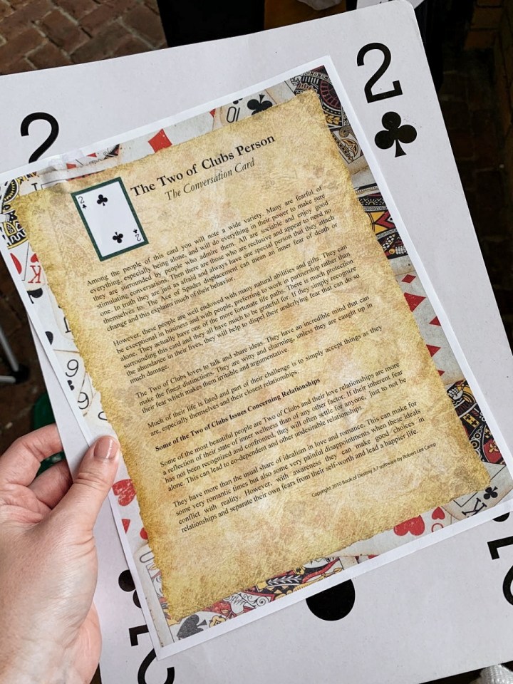 A giant 2 of clubs playing card. A description of what a "two of clubs" person tends to be like from the Champagne Destiny Reading. 