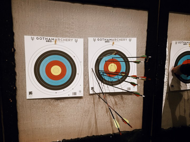 two archery targets; one target is blank and the other is full of eight bows because the shooter kept missing and landing on her husband's target at Gotham Archery