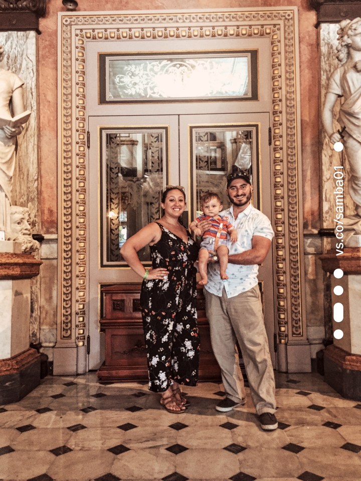A family stands in front of the doors leading to the National Theater of Costa Rica.