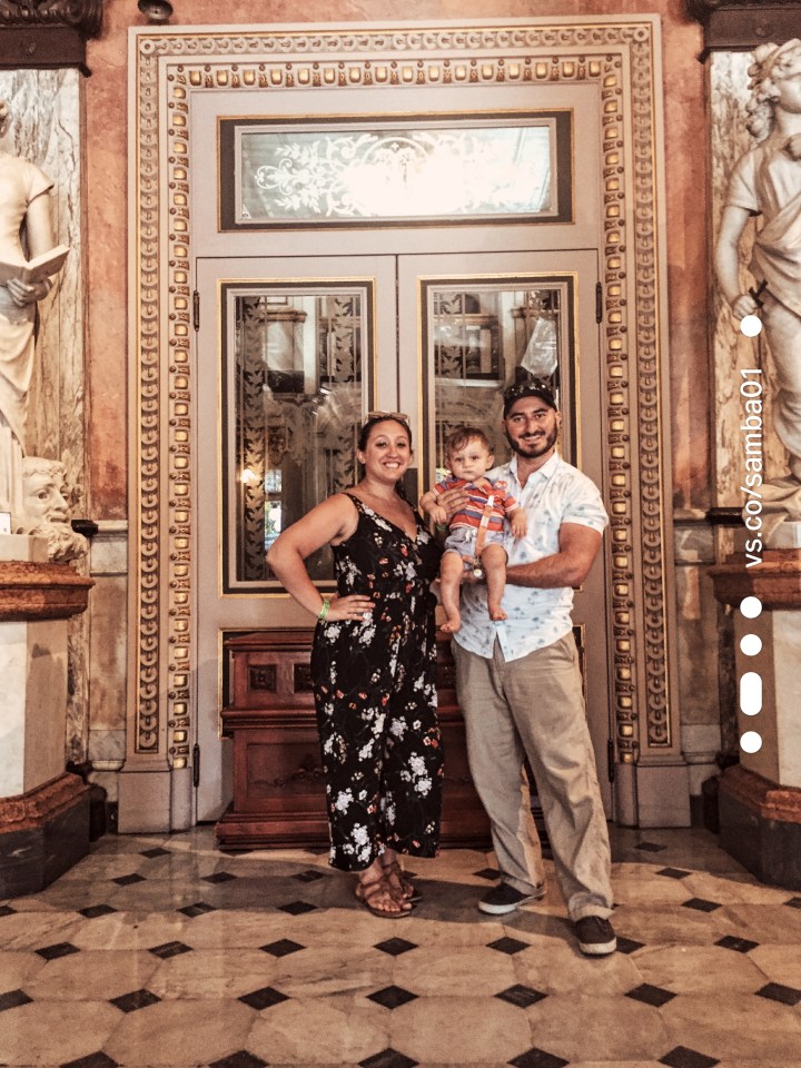 A family stands in front of the doors leading to the National Theater of Costa Rica. 