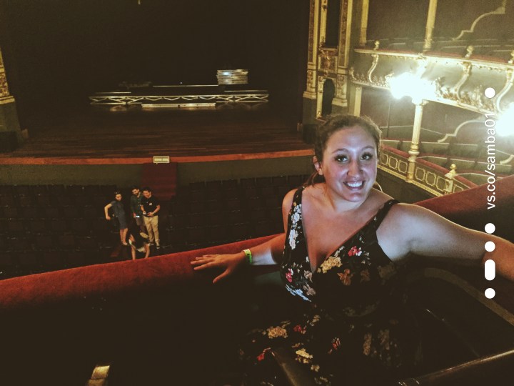 A woman posing in front of the stage at the National Theater