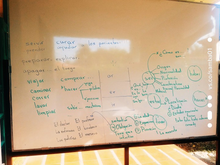 A white board at Academia Tica is full of Spanish verbs and how to conjugate them. 
