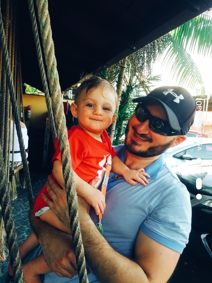 Father and son sit on a swing at a taco lunch spot in Jaco, Costa Rica.