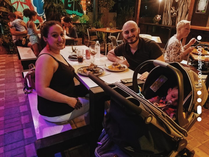 A couple and young child out at a restaurant