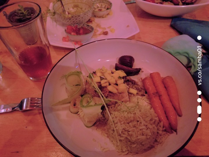 A plate of locally sourced food including rice, fish, carrots, pineapple, and cucumber. A dish for the article Eating in Jaco, Costa Rica. 