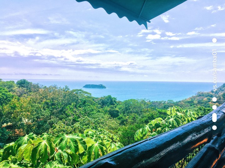 A view of a beautiful blue ocean and green jungle from the deck at Manuel Antonio's El Avion restaurant