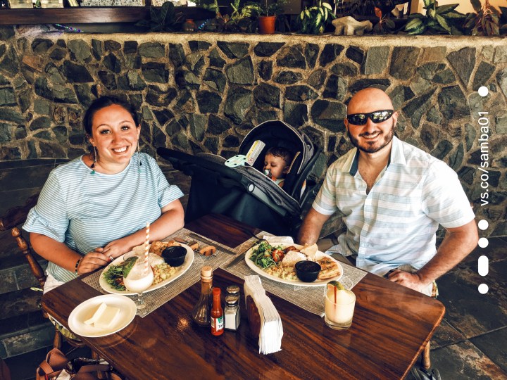 Two parents and their infant sit for lunch 