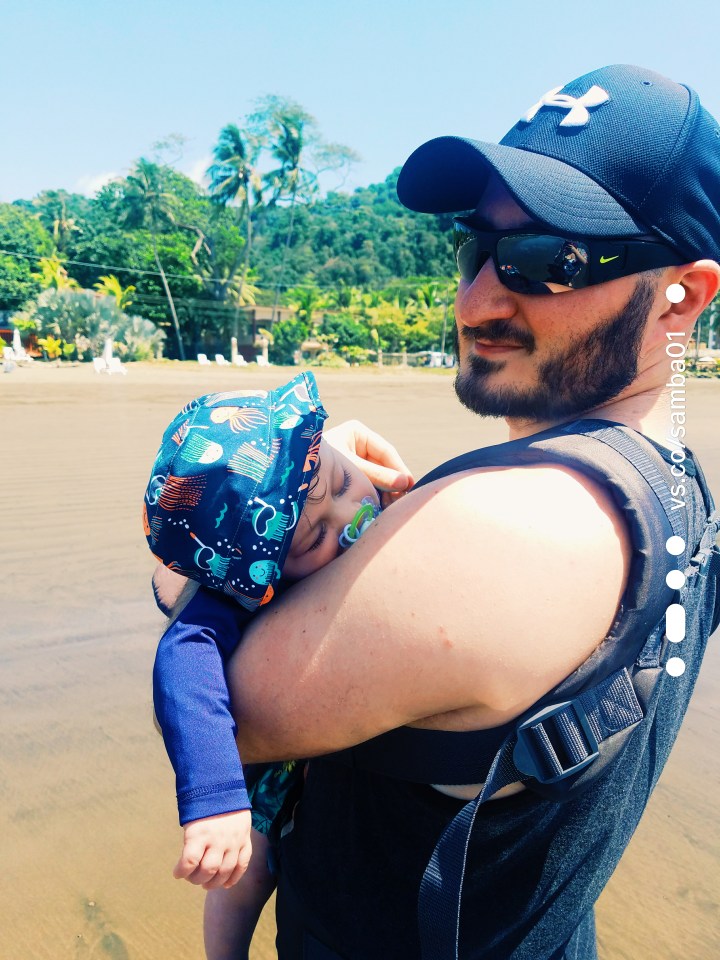 A father and son standing on a beach in Jaco