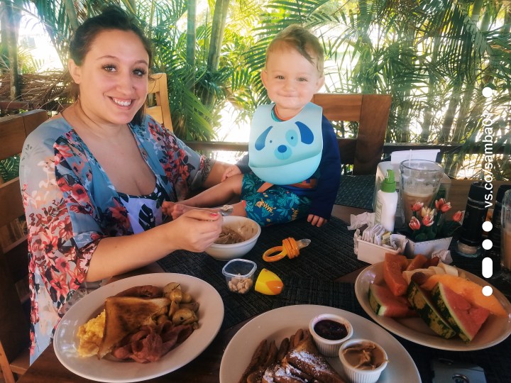 A woman and a child sitting on a table having breakfast