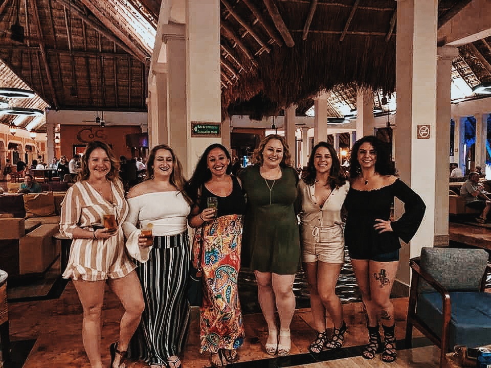 A group of girls who are best friends celebrates an impending wedding at the bar at Now Sapphire resort