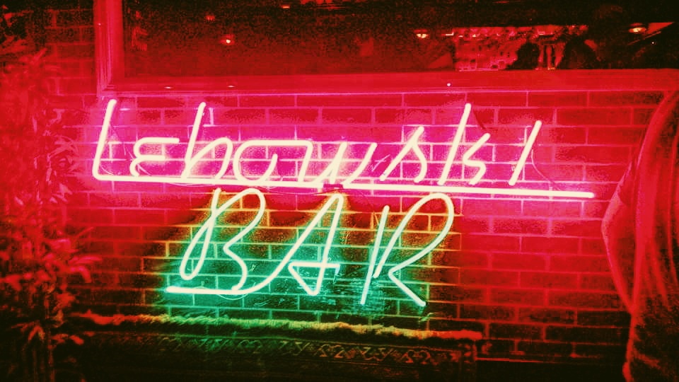 A neon sign reading, "Lewbowski Bar" welcomes guests in Reykjavik Iceland. 
