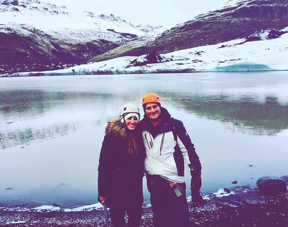 A couple poses at the bottom of Solheimajokull Glacier