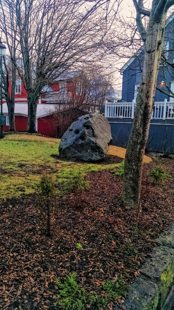 An elf stone sitting in a field in Reykjavik 