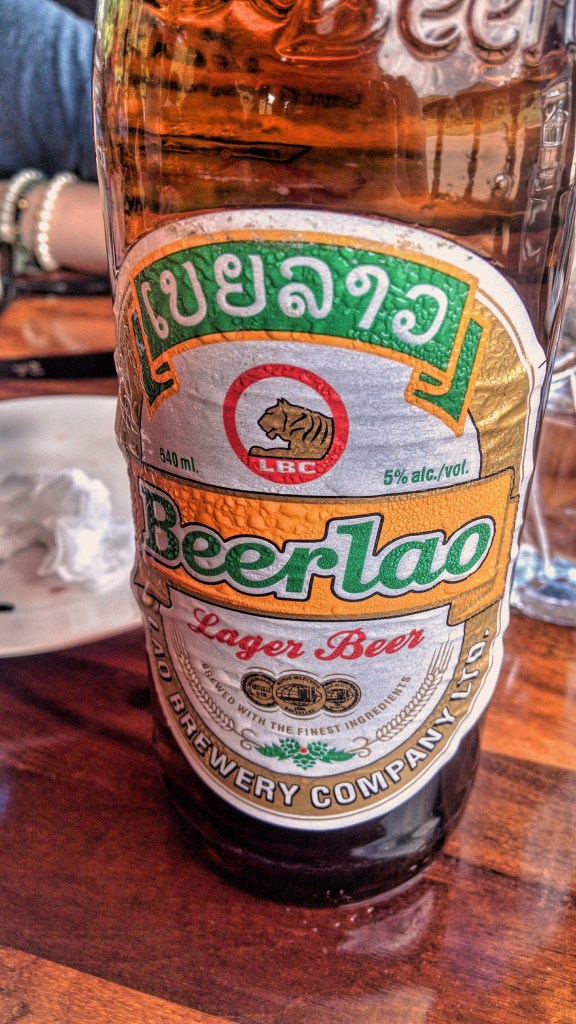 A bottle of "Beerlao" with its yellow, gold, green, and white label and tiger emblem