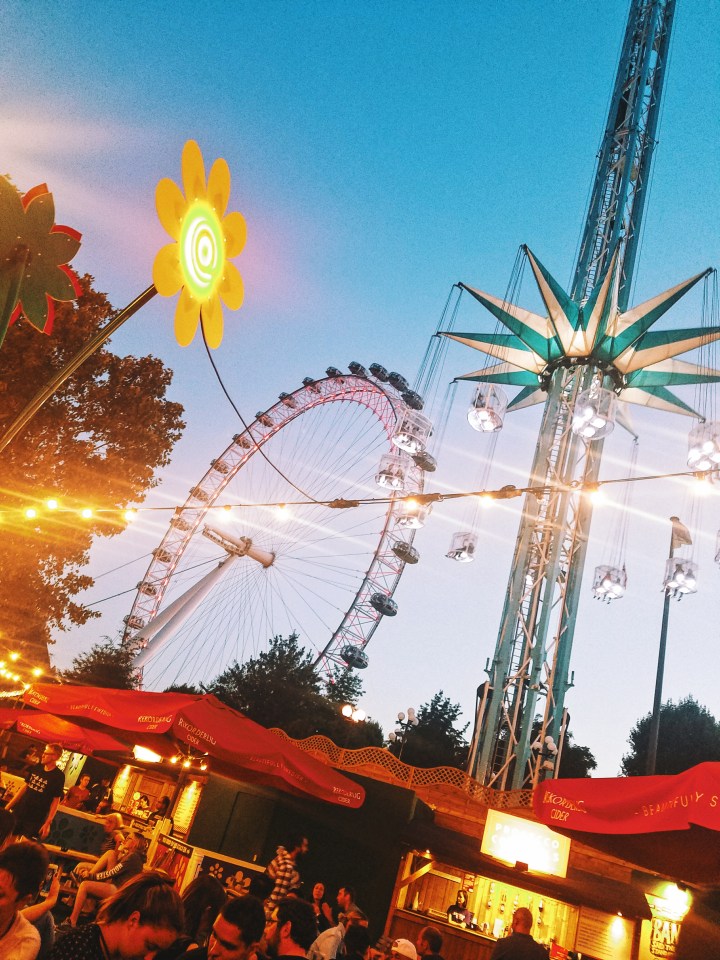 Lights, a Ferris wheel and a spinning chair ride at dusk at Wonderground in London. Check it out during your first time in London.