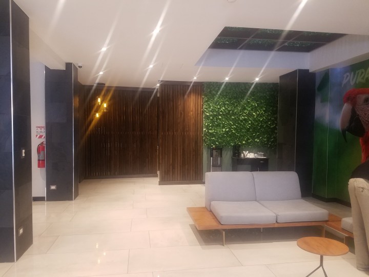 The lobby of Hotel Cultura Plaza with white tile floors and a white couch. 