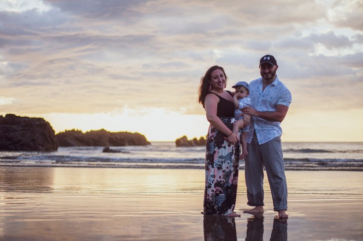 A couple and a young child pose on a beach in Jaco, Costa Rica