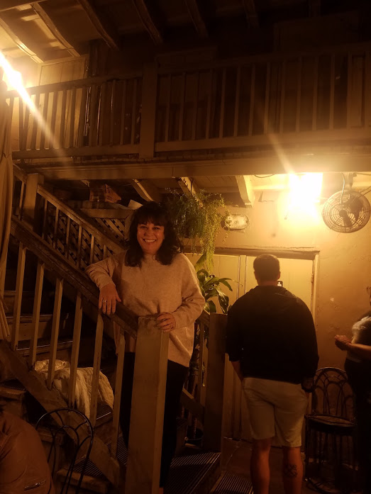A woman standing in the courtyard of The Gumbo Shop