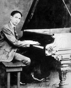 Jelly Roll Morton sitting at the piano. 