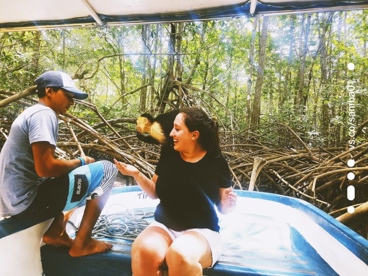 A tour guide and a woman with a monkey on her shoulders