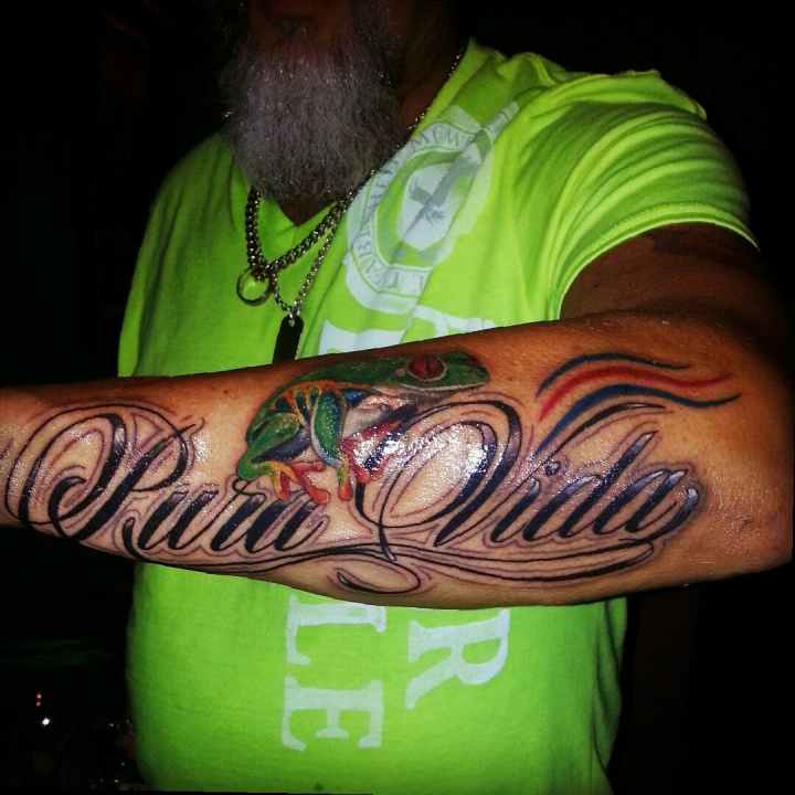 A man holding up his forearm with a large tattoo