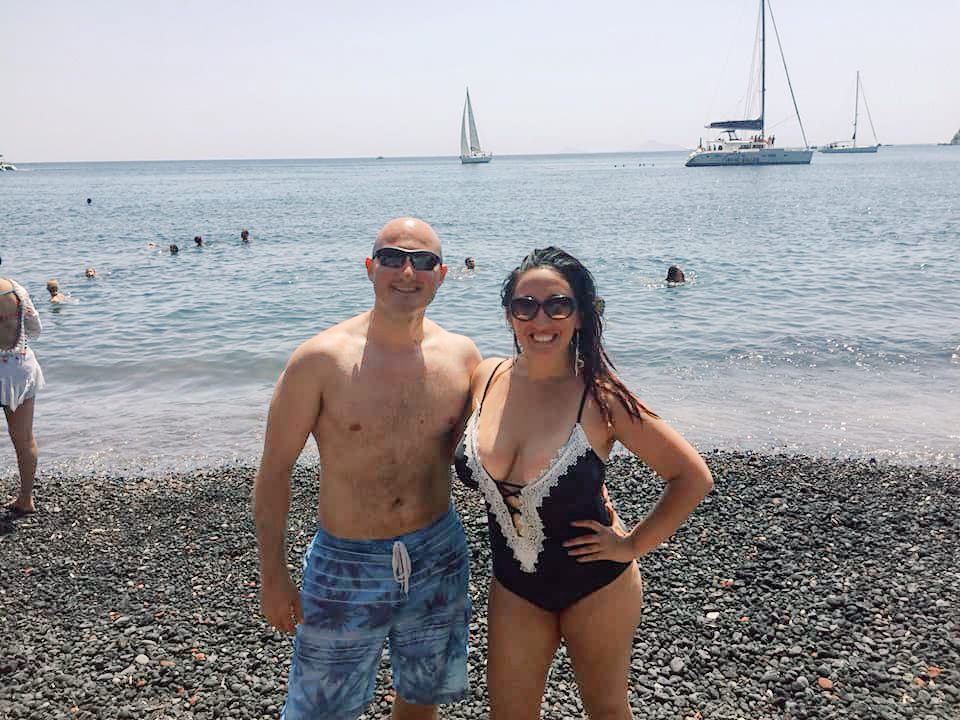 A couple poses on a beach