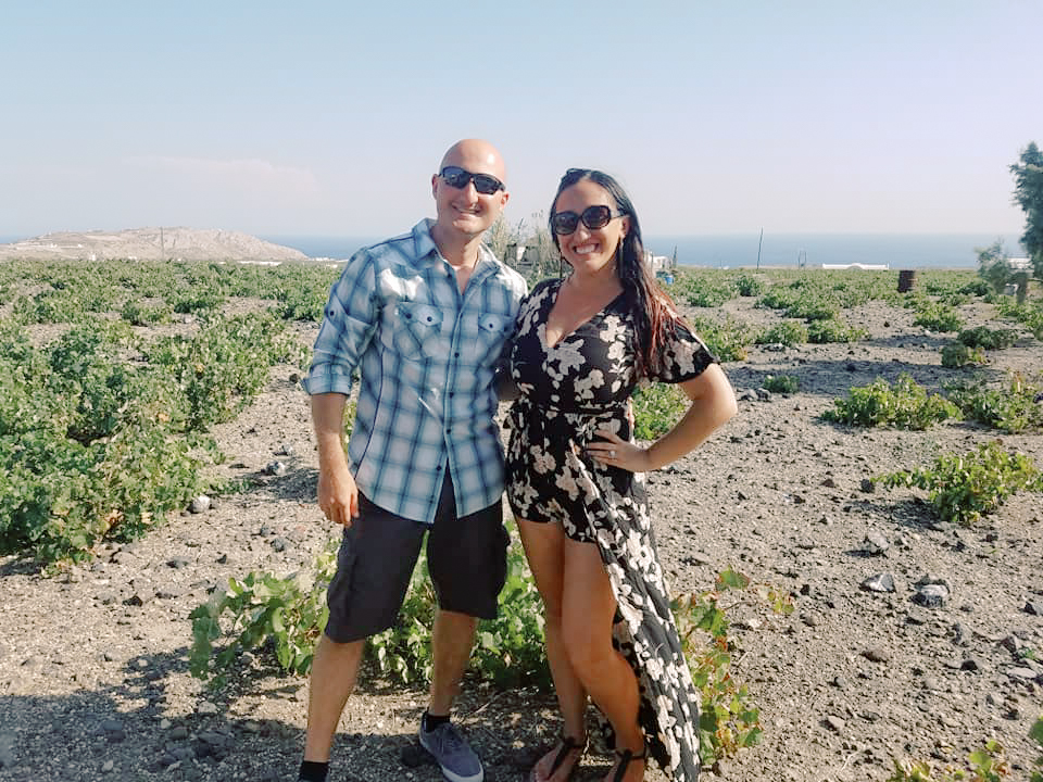 A couple poses in the vineyards in Santorini