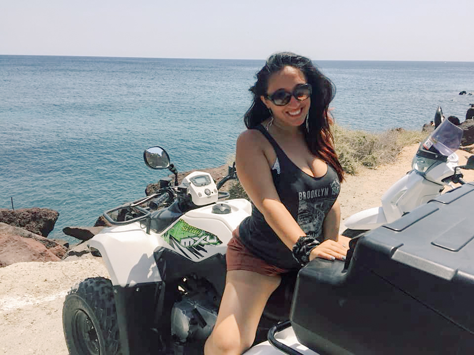 A woman sits backwards on a quad 