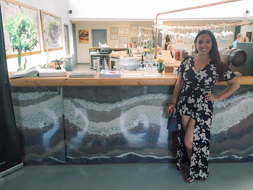 A woman poses next to a winery in Santorini