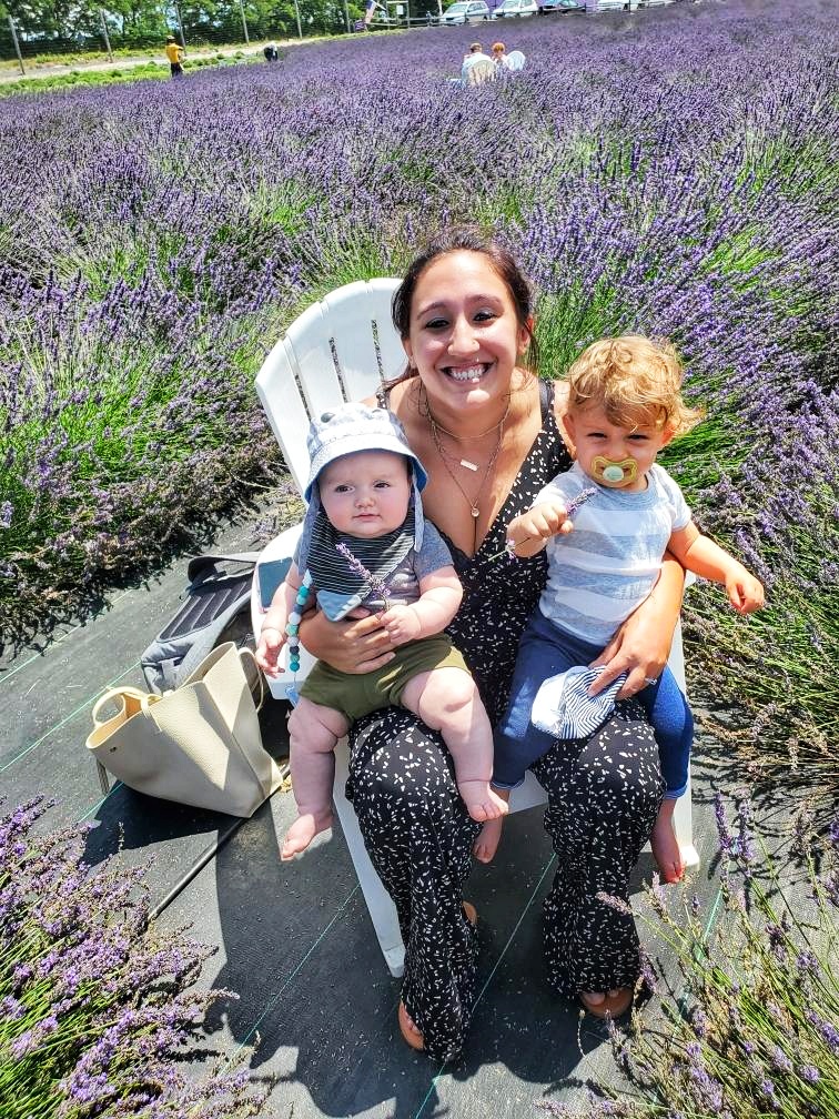 A woman and two children sit in the middle of the flower fields