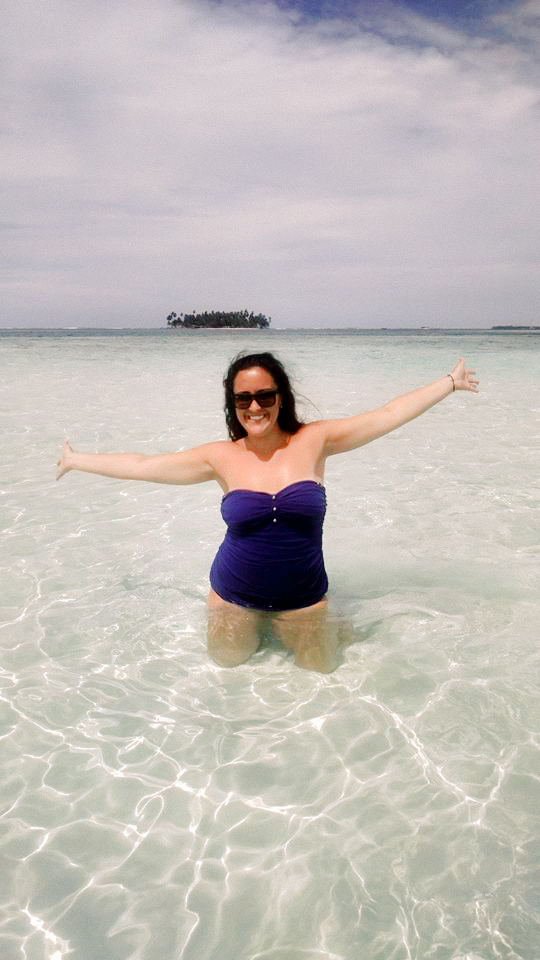 A woman posing with arms outspread in the water of the Guna Yala Islands