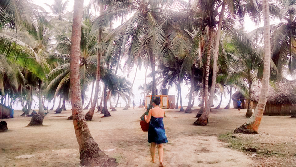 A woman walking amongst the palm trees