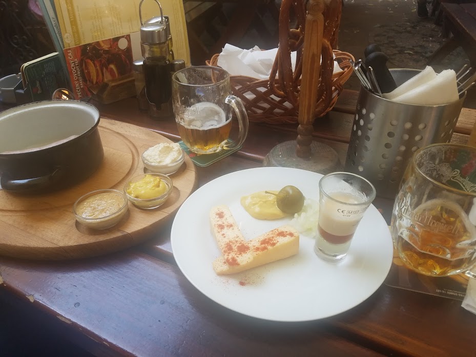 A table of food and beer at a restaurant in Prague