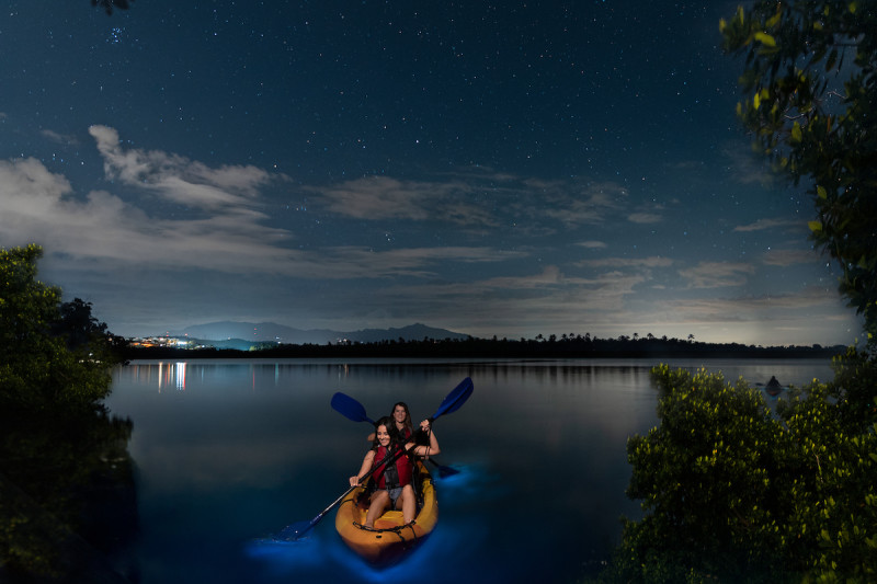 Kayakers in the foreground of a landscape shot of a body of water