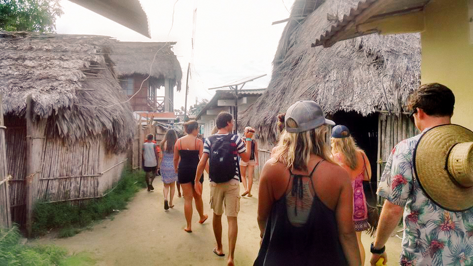 A crowd of tourists walking amongst a village