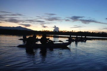 A silhouette of kayakers on the water