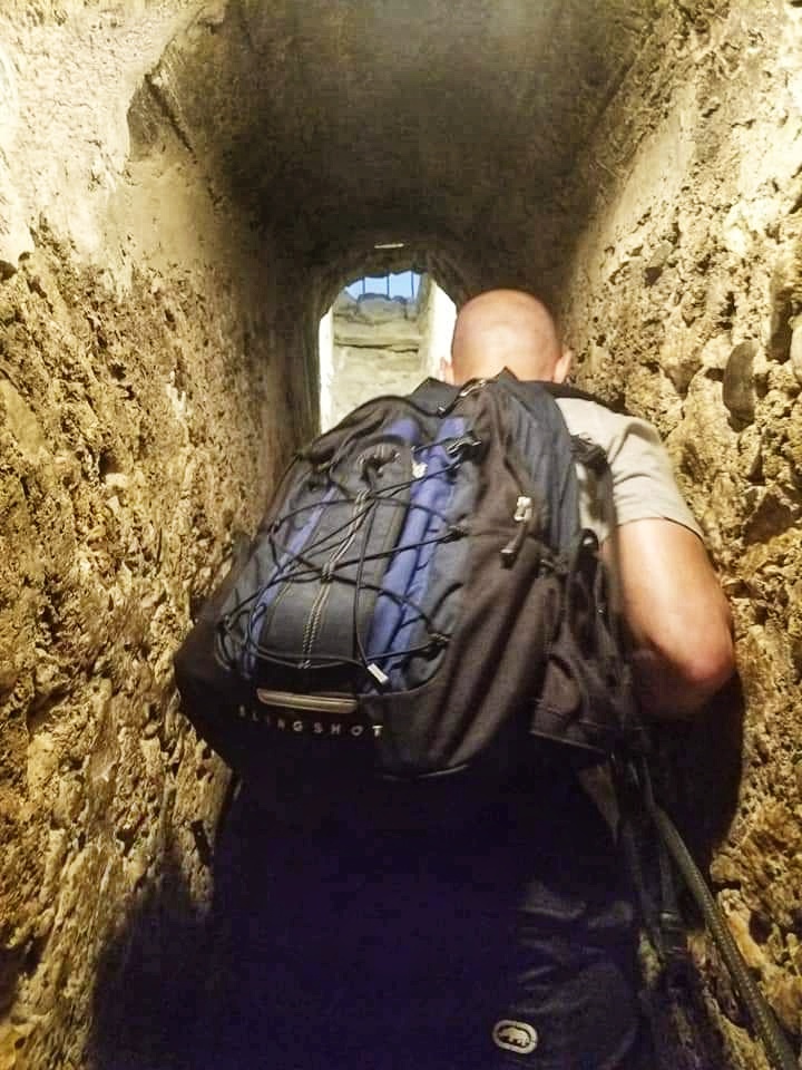 A man walking through a short passage way