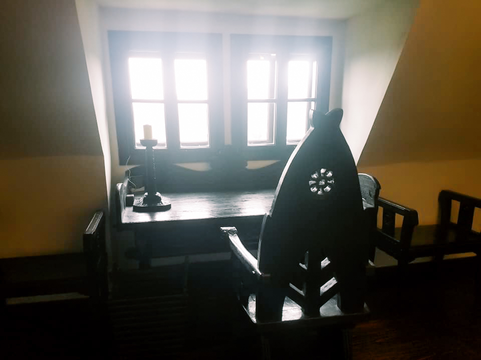 A historical desk and chair facing a window