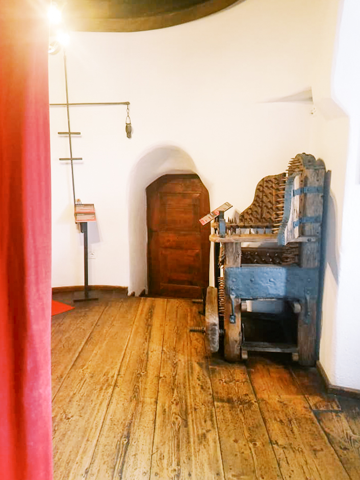 A wooden room with medieval torture devices