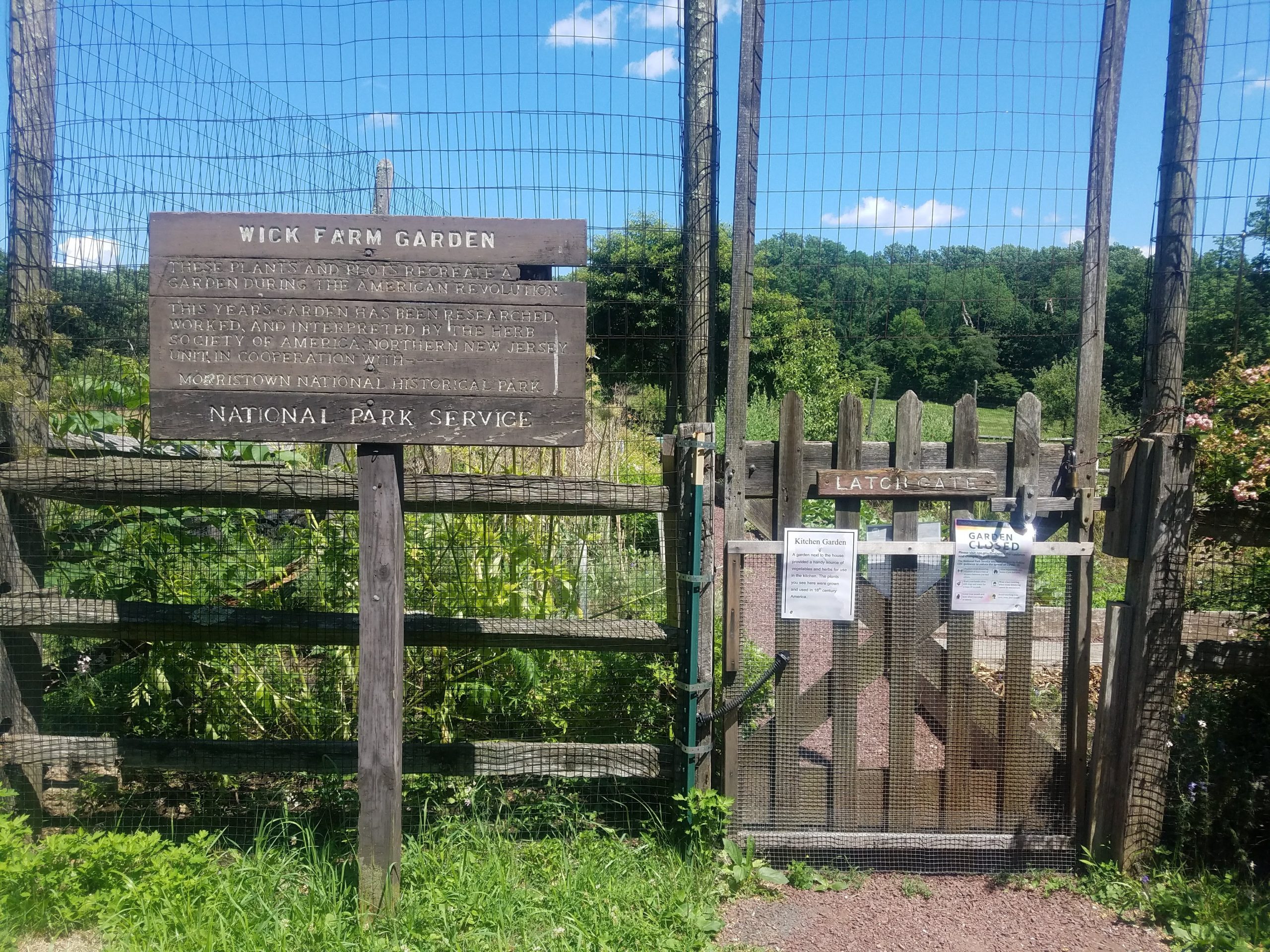 A sign and gate labeled "Wick Farm Garden" in Jockey Hollow Park