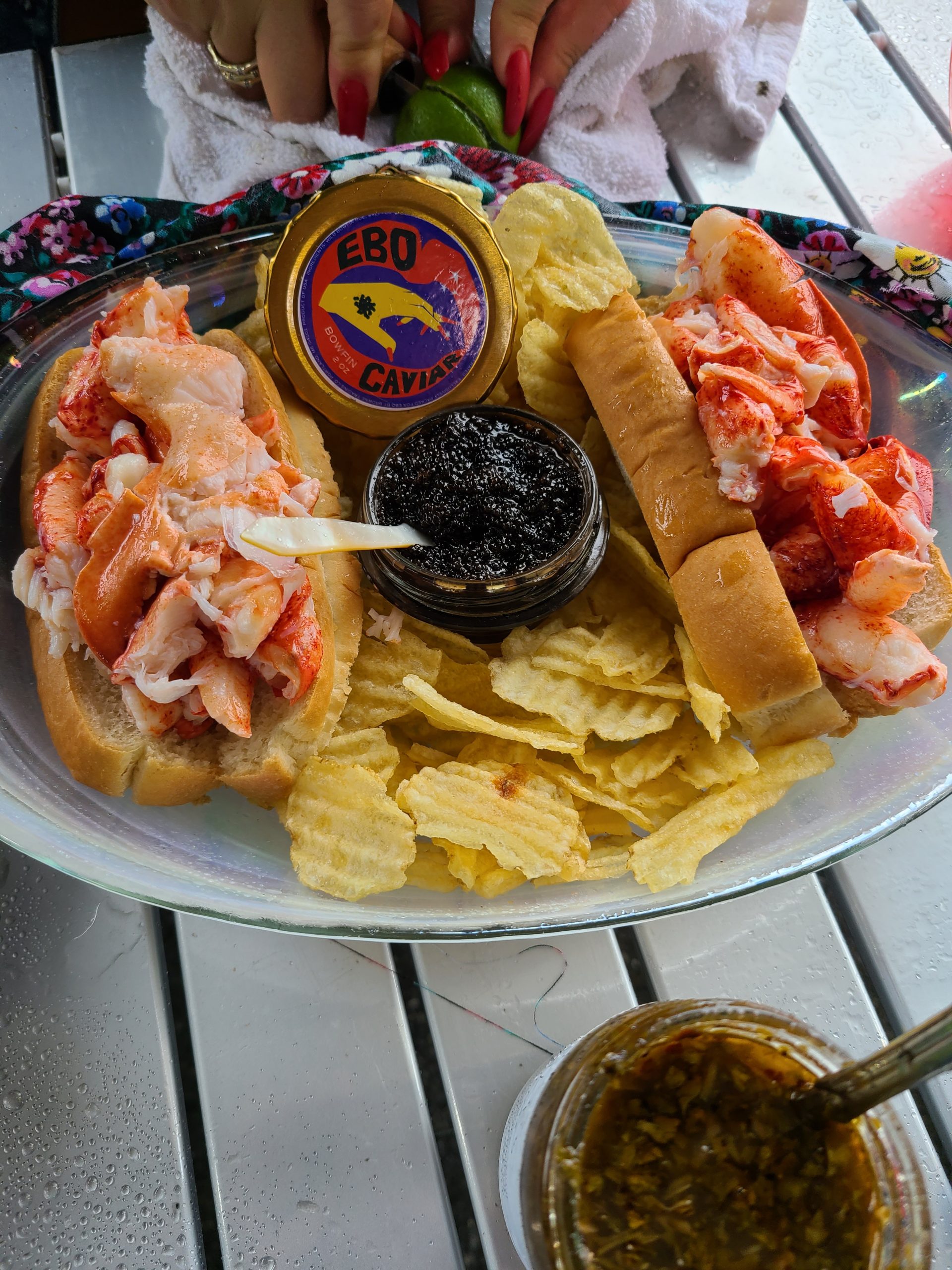 A plate of lobster rolls, chips, and caviar