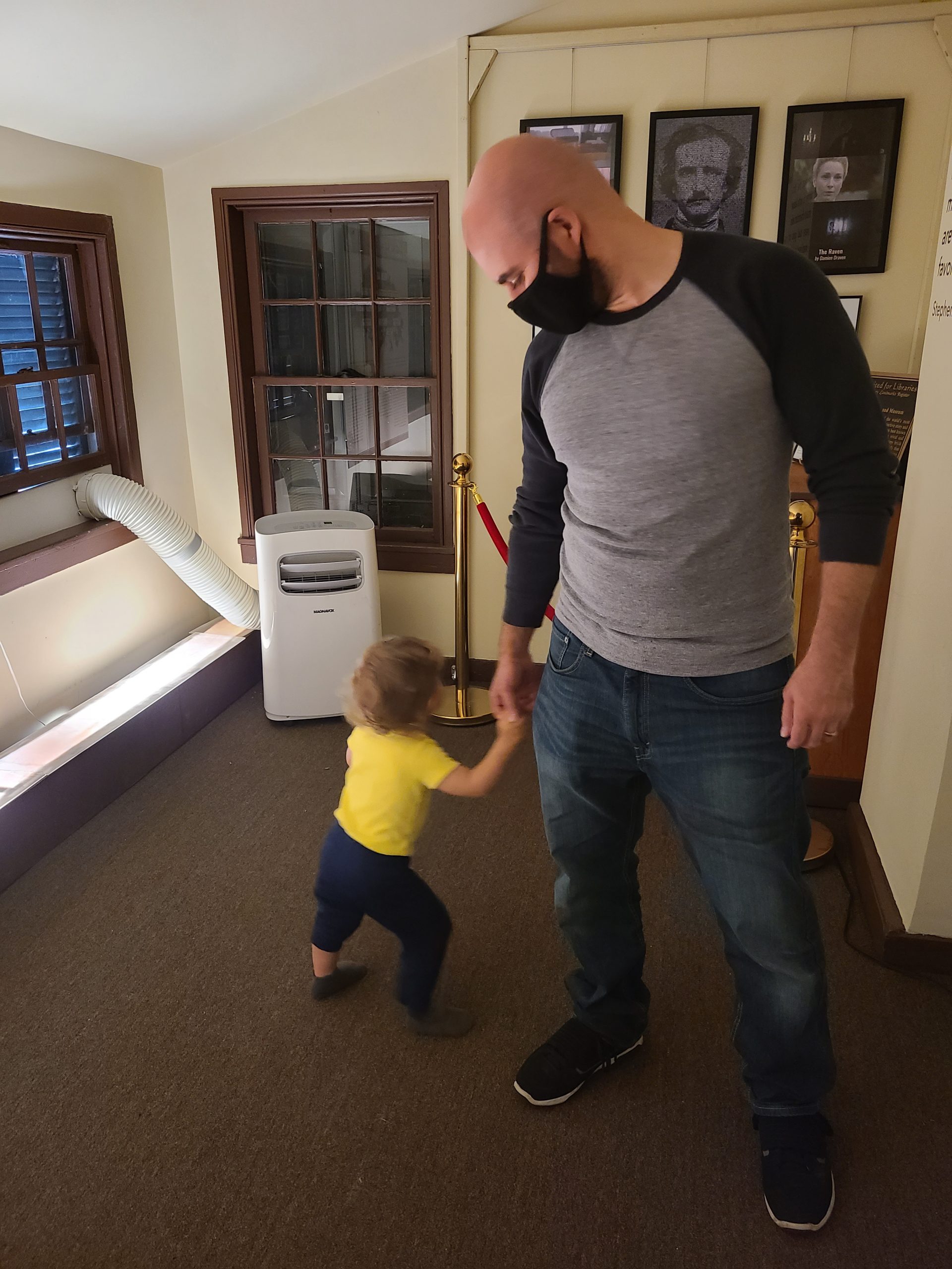 A man and child walking around in the Edgar Allan Poe house
