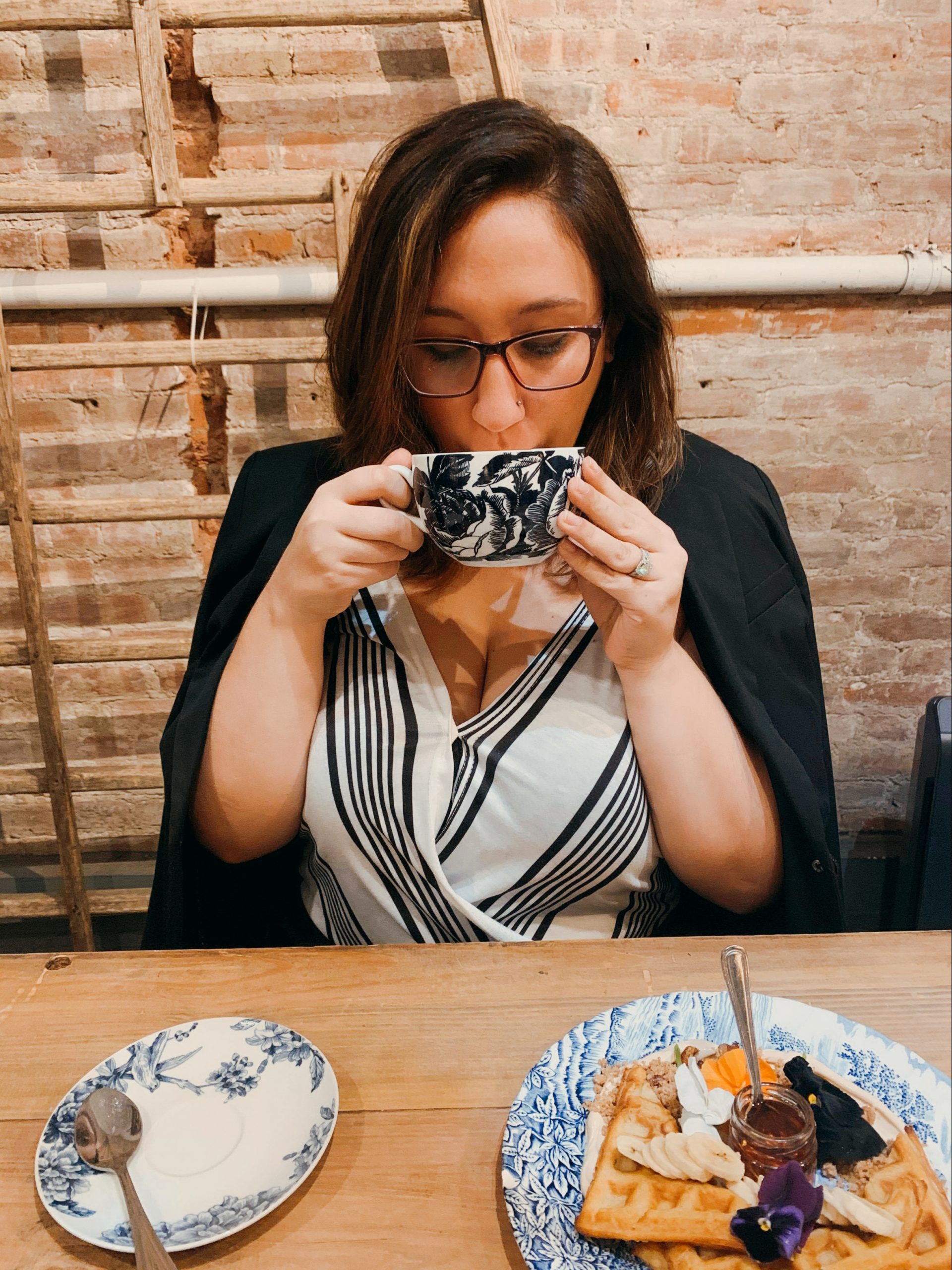A woman drinks from a cup of coffee