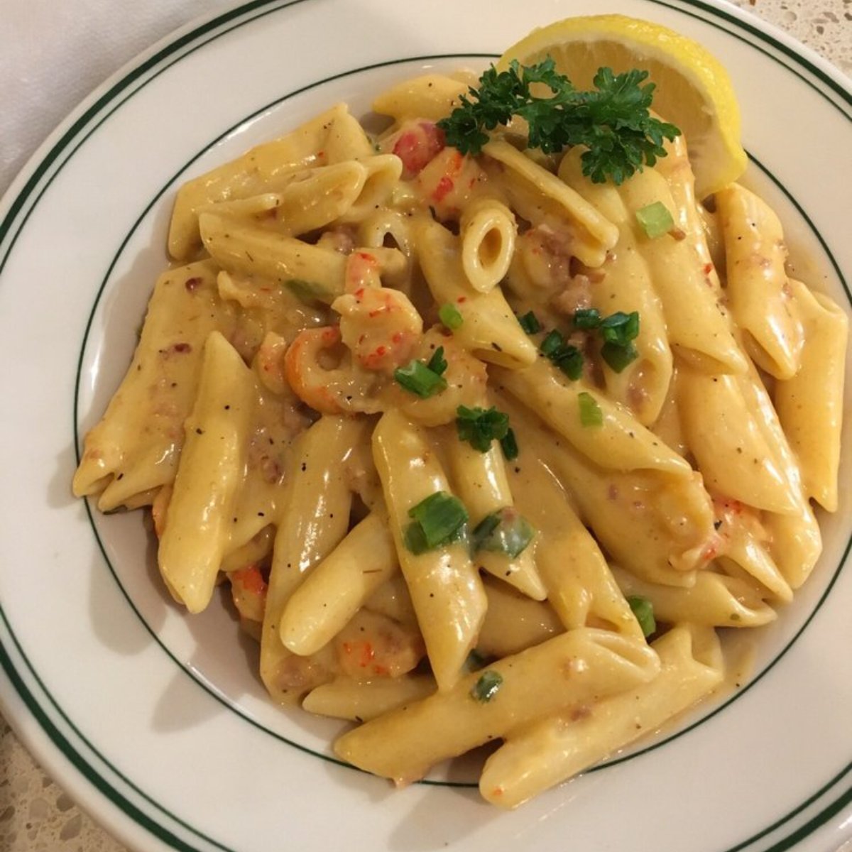 A plate of penne pasta and crawfish tails