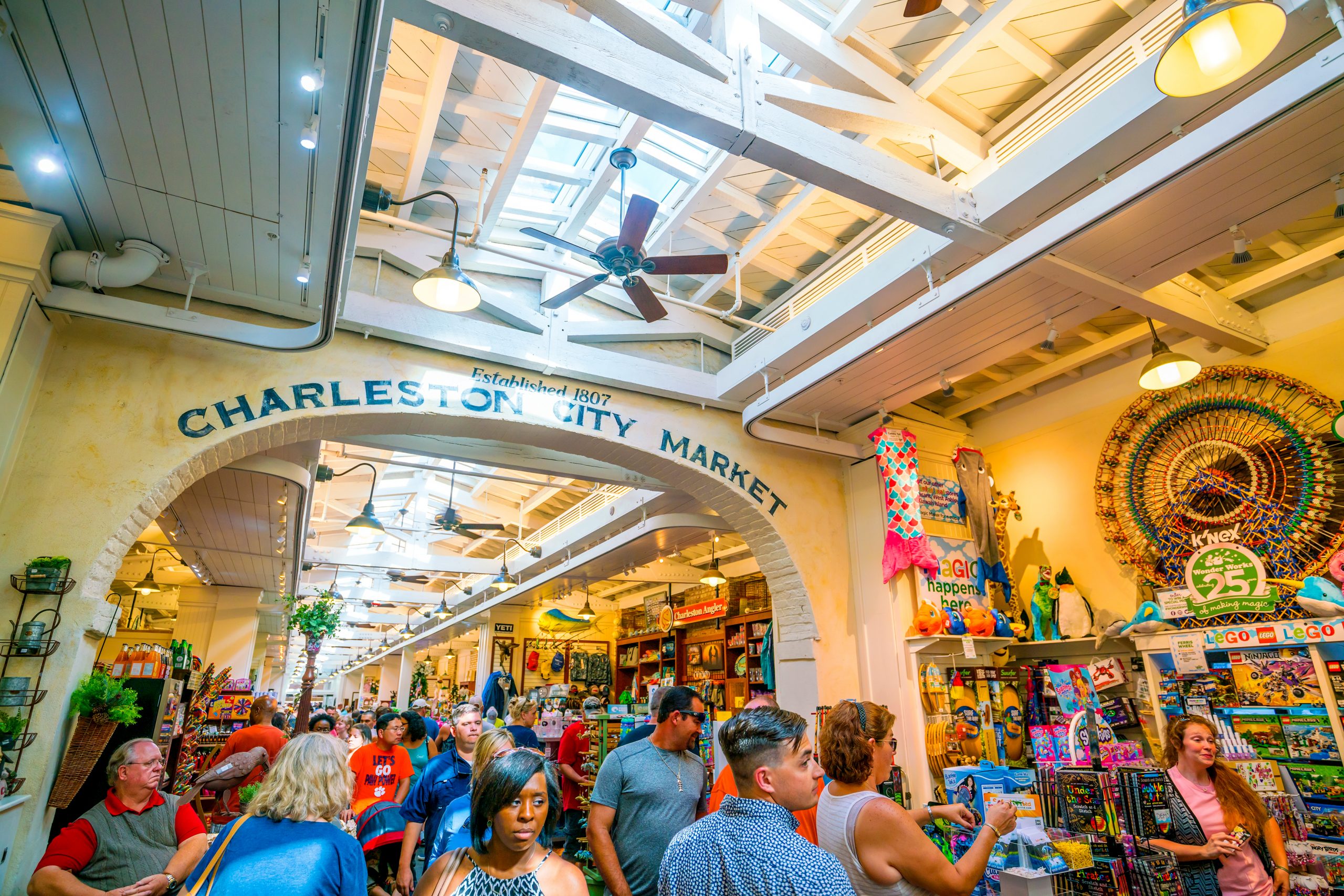 A crowd of tourists navigating through charleston marketplace vendors